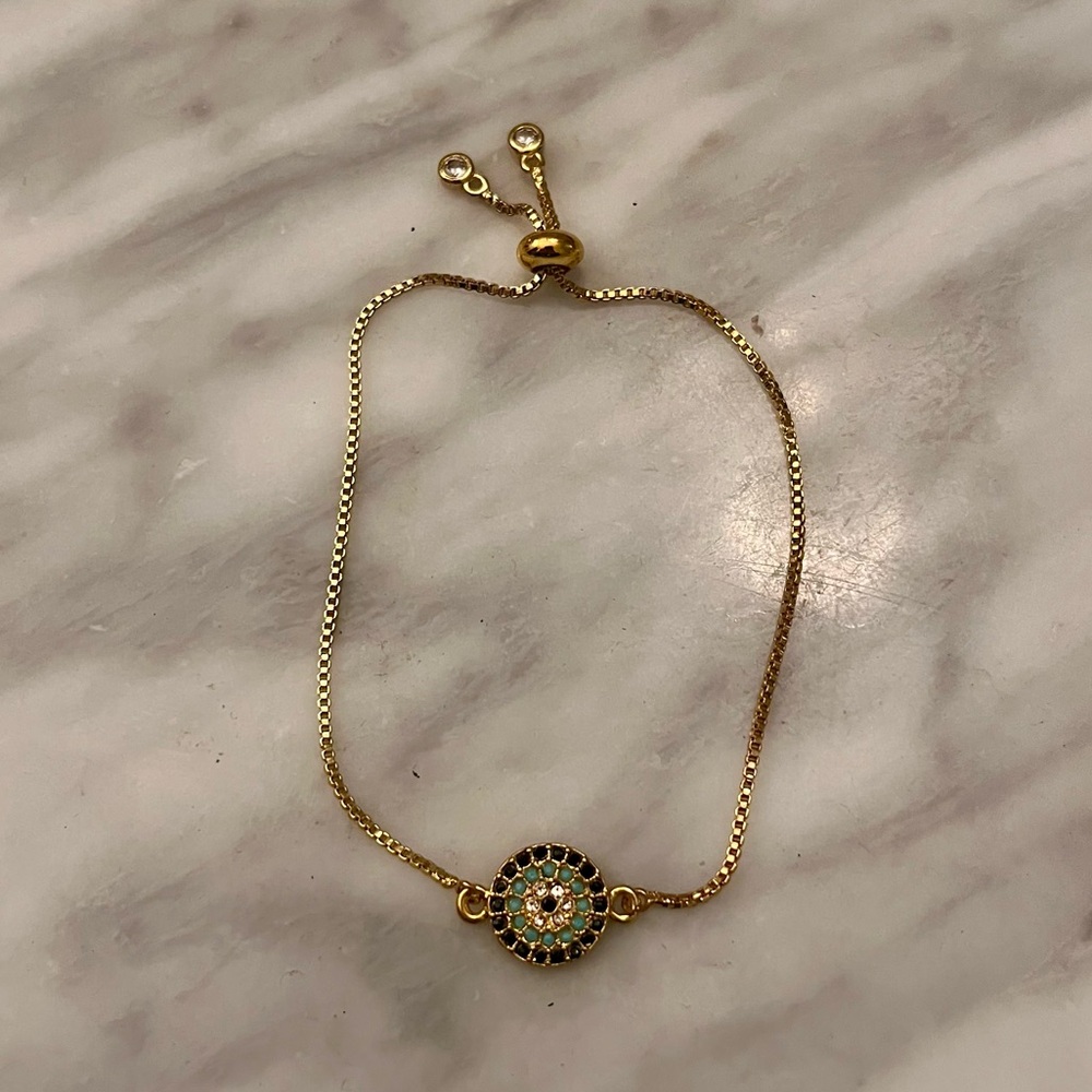 Elegant Gold Tone Evil Eye Bracelet with Intricate Crystal Design, Slide Closure